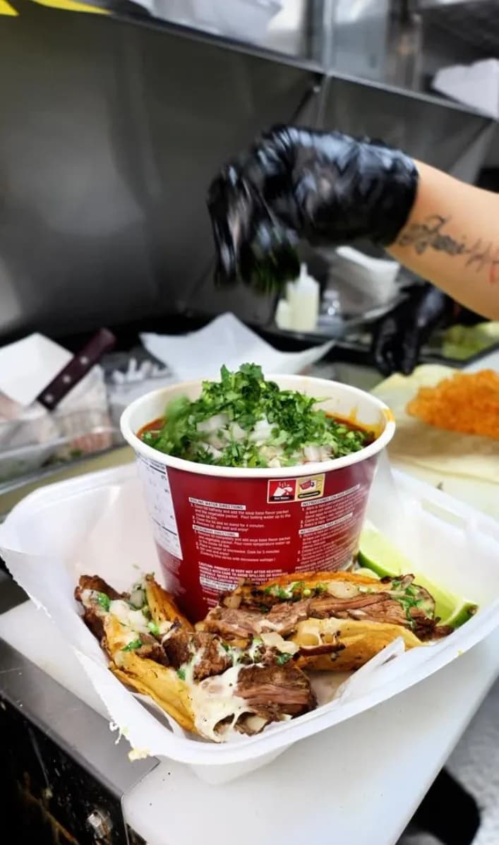 Quesabirria tacos with consome prepared fresh inside the Delicias Tacos truck in Chicago
