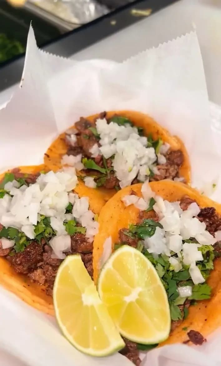 Carne asada street tacos with onion, cilantro and lime from Delicias Tacos