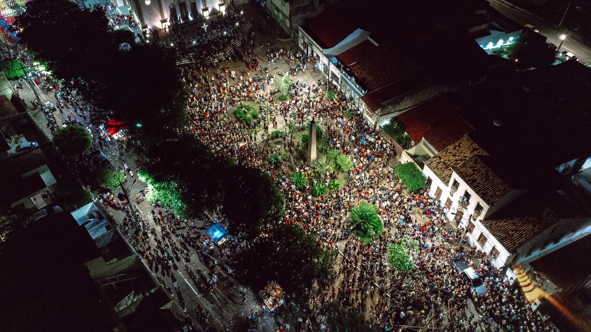 Aerial view of a packed street festival filling a square at night