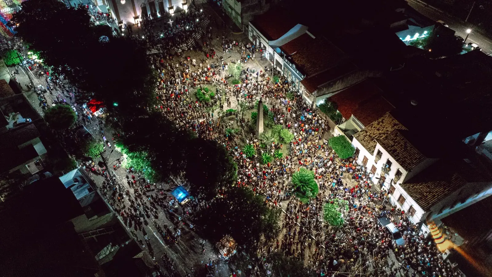 Aerial view of a packed street festival filling a square at night